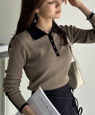 Model wearing the long-sleeve gold-rimmed button ribbed polo knit with a contrasting black collar and button placket.