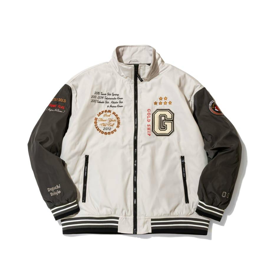 Front view of the men's Gold Ship graphical blouson jacket showing a zip front, contrasting dark sleeves, embroidered patches, and striped ribbed hem.