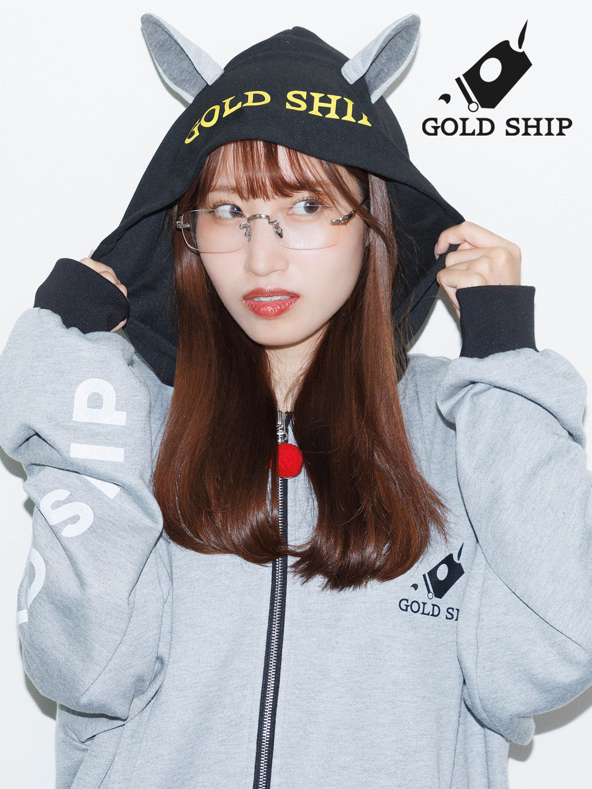 Model wearing the Gold Ship horse-ear hoodie sweatshirt with a gray body and black hood printed with 'GOLD SHIP'.