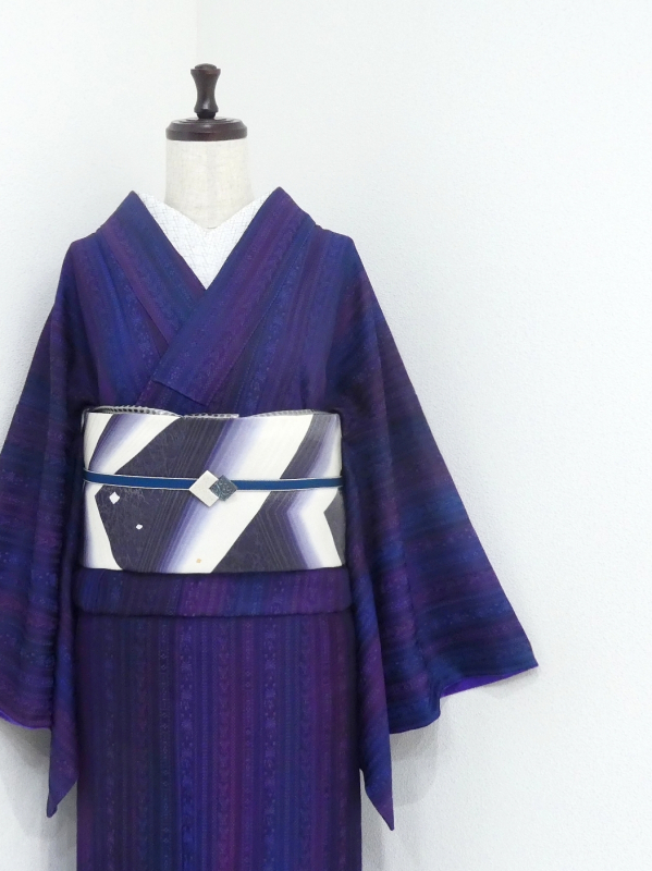 A deep purple gradient women's kimono with vertical-line pattern displayed on a mannequin with an obi.