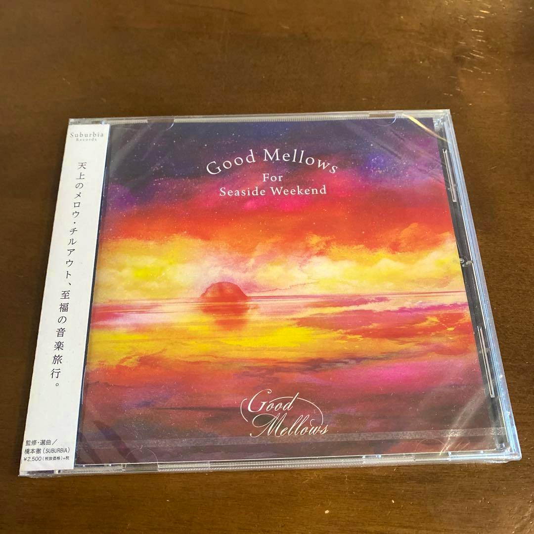 The front cover of the Good Mellows For Seaside Weekend CD in its clear jewel case on a wooden surface.