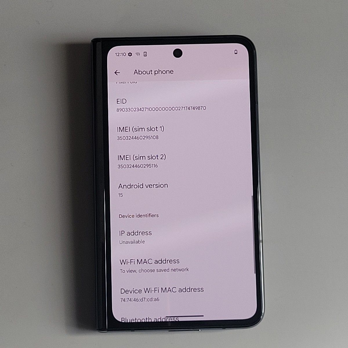 Opened Google Pixel Fold smartphone front showing the About phone settings screen.