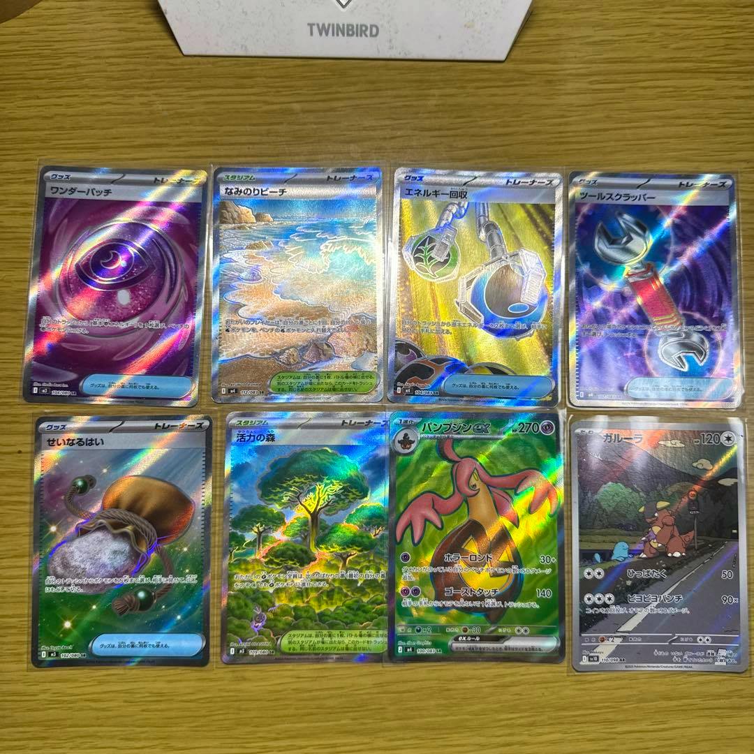 Fronts of eight holographic Pokémon trading cards laid out in two rows on a wooden table, showing Pumpjin SR, Kangaskhan AR and other trainer SR cards.