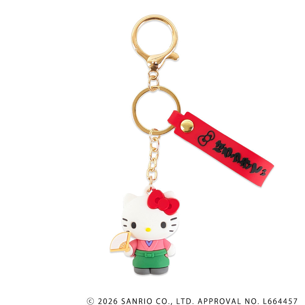 Front view of a rubber Hello Kitty keychain attached to a gold key ring with a red rectangular tag.