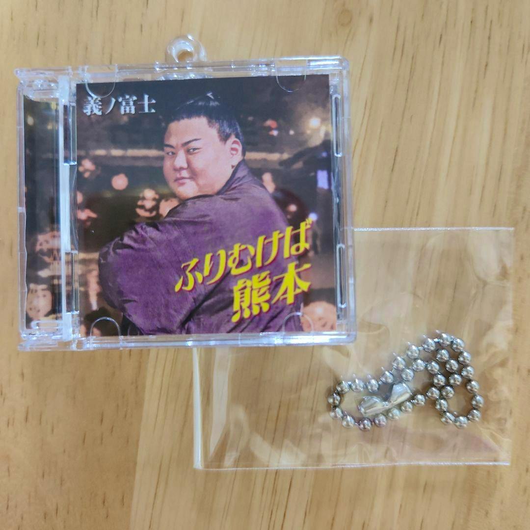 CD-style keyholder of 義ノ富士 and a detached metal ball chain on a wooden surface.