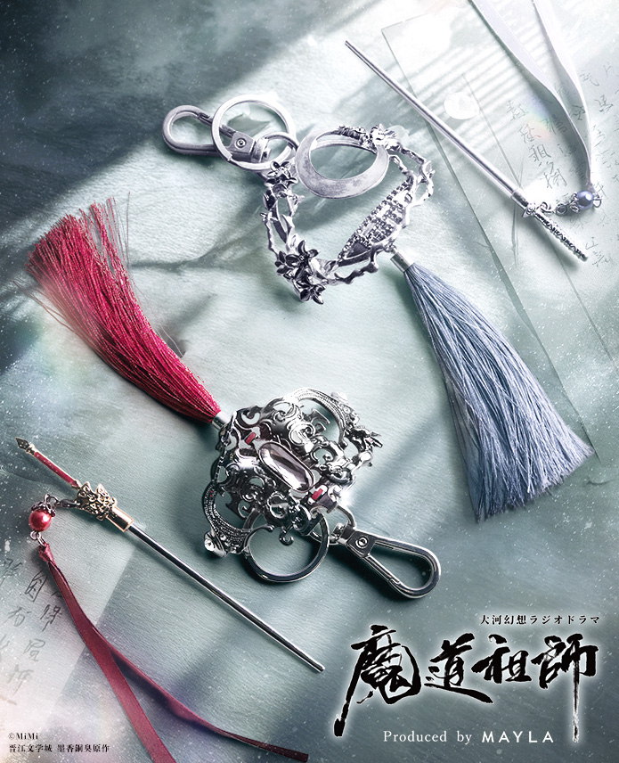 Decorative hair accessories and charms—silver filigree hair ornament, two tassel hair sticks, and metal charm clips—laid out on a textured surface.