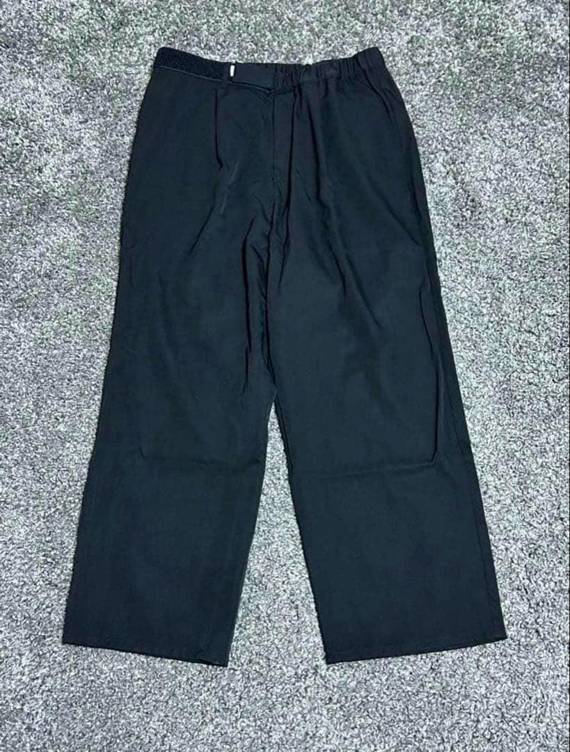 GraphpaperScale Off Wool Wide Chef Pants shown front view laid flat on a gray carpet.