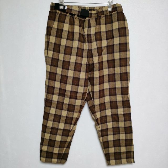 Front view of brown and beige wool check pants hanging against a white background.