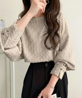 Woman modeling a grey women's blouse (polyester) with textured fabric and buttoned cuff sleeves.