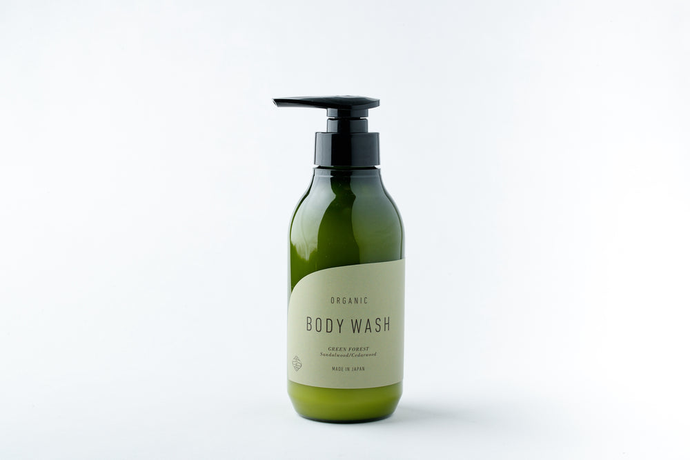 A green pump bottle of GREEN FOREST BODY WASH on a white background.