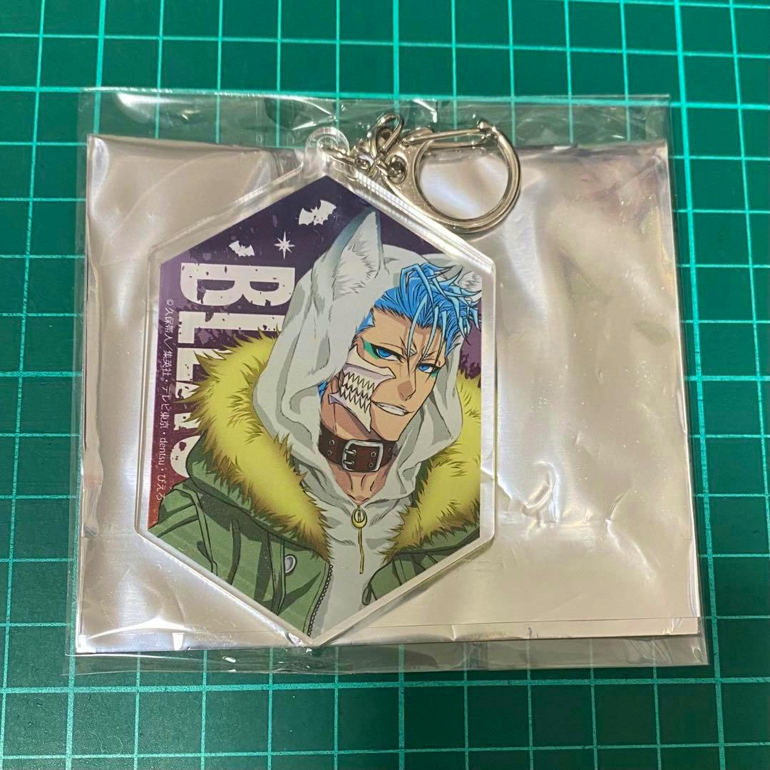 A packaged acrylic keychain of グリムジョー・ジャガージャック (Grimjow) from BLEACH displayed on a green cutting mat.