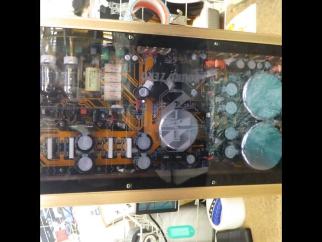 Internal circuit board and capacitors of the GROUND ZERO GZ-GZPA Reference 2T amplifier visible through a transparent cover.