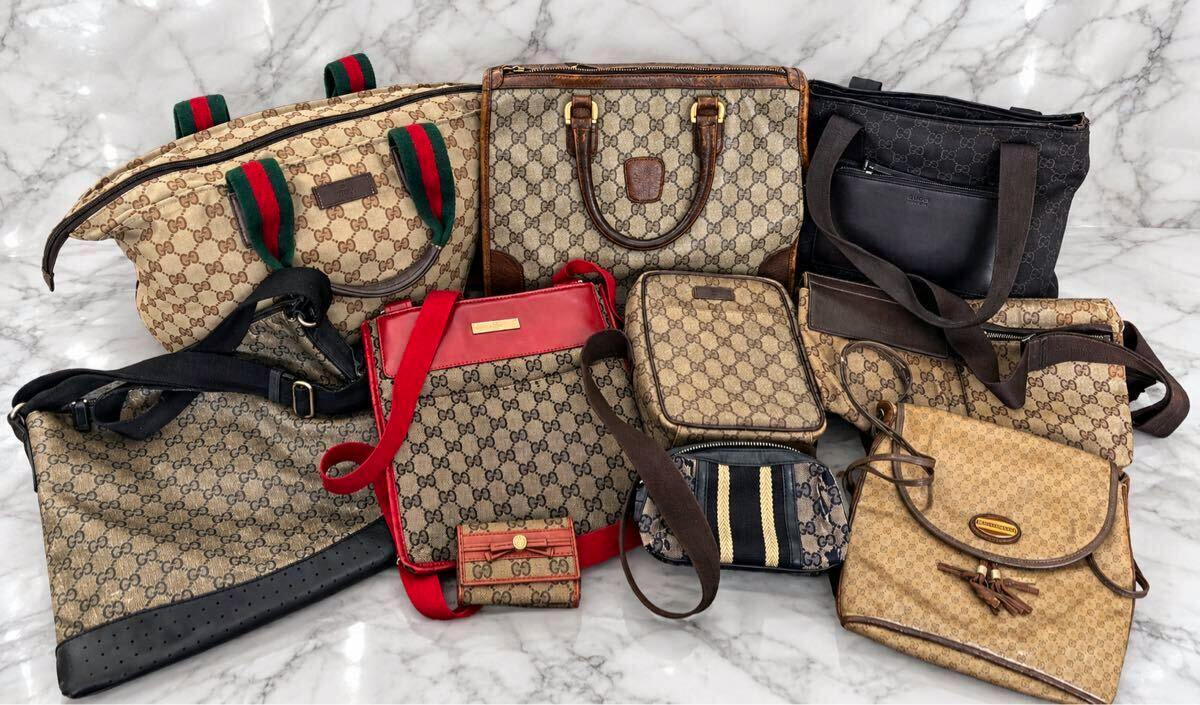 A group of Gucci canvas bags and small accessories with GG pattern arranged on a marble surface.