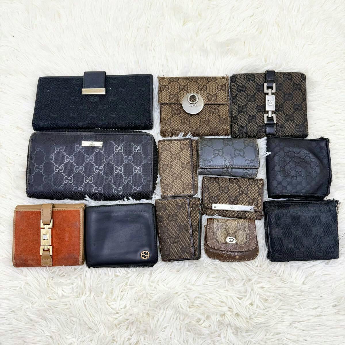 Top-down photo of multiple Gucci wallets and coin cases arranged on a white fur background.