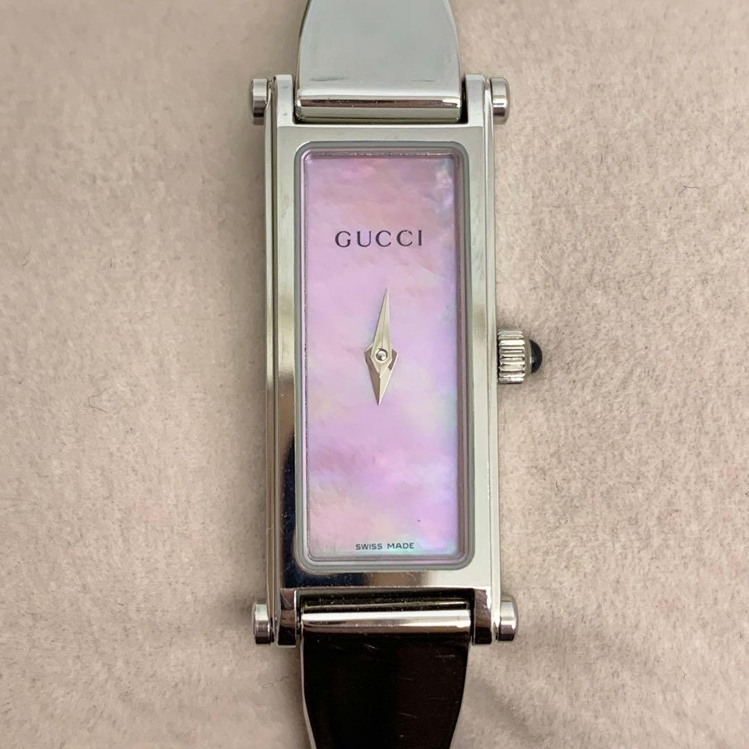Front view of the Gucci 1500L women's metal-case quartz watch showing the rectangular pink shell dial and single hand on a light background.