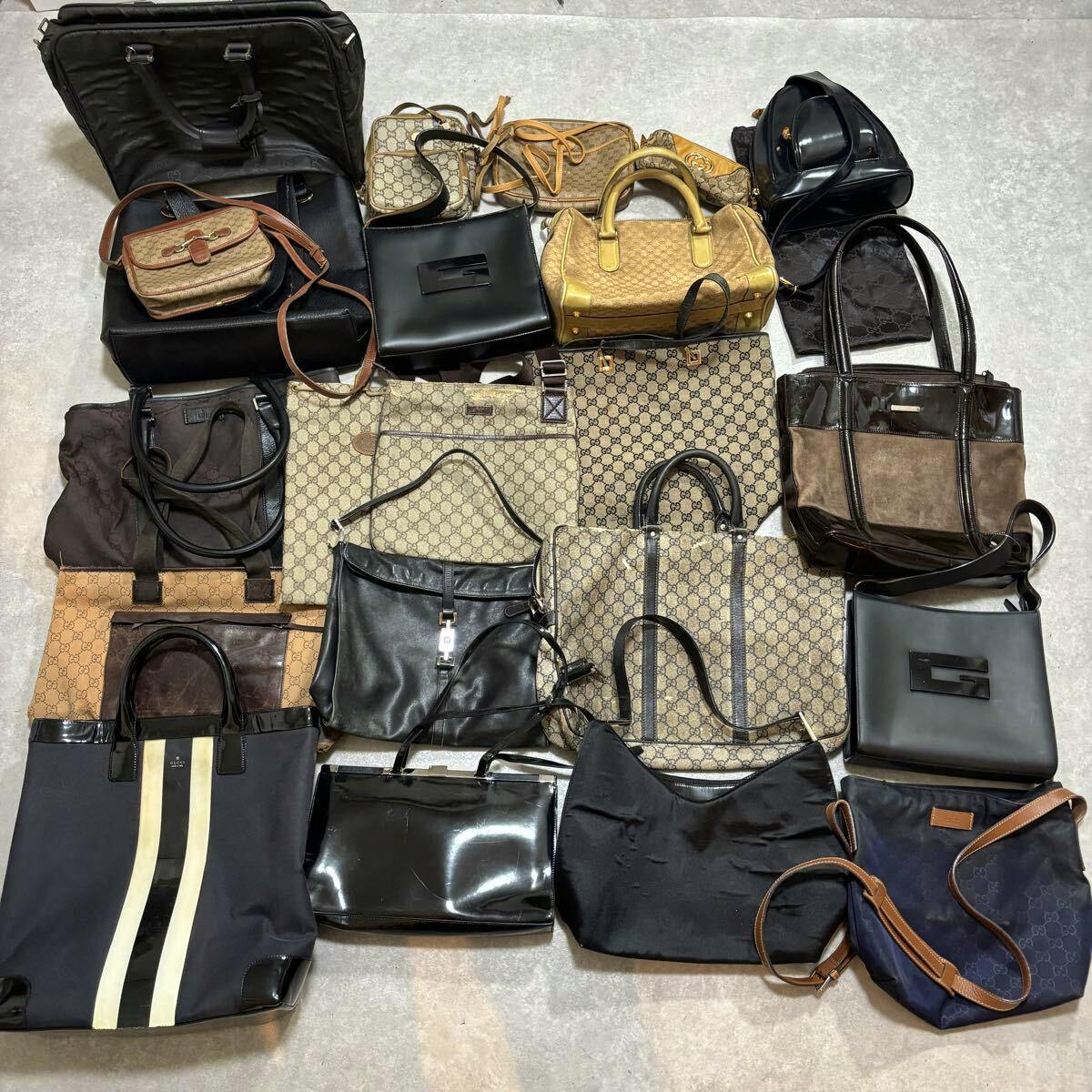 Assorted GUCCI bags and totes laid out on the floor, showing monogram and leather styles.