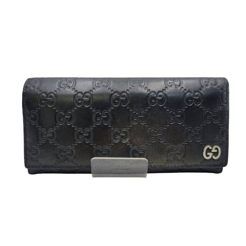 Front view of a black Gucci long leather wallet with embossed GG pattern and metal GG logo.