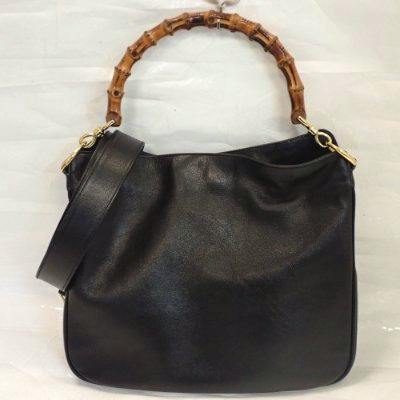 Black leather Gucci bamboo-handle 2way handbag with a detachable shoulder strap on a white background.