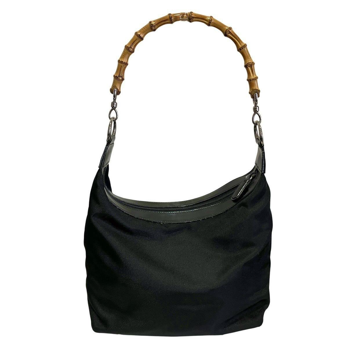 Front view of a black Gucci nylon handbag with leather trim and a bamboo top handle.