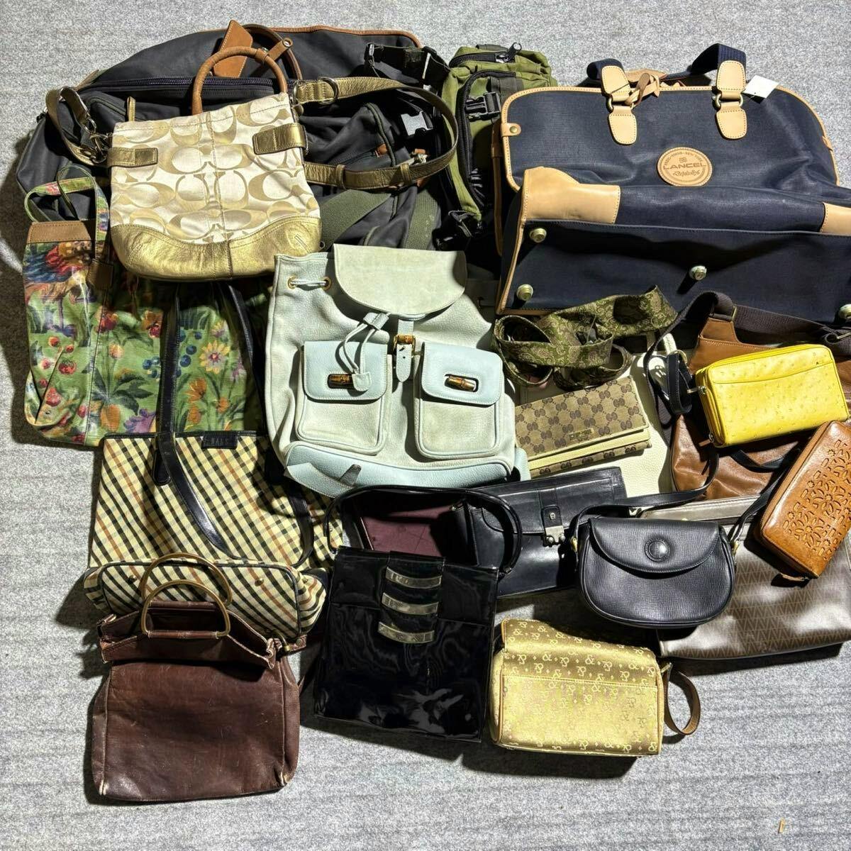 Multiple assorted handbags and shoulder bags laid out on a carpeted floor photographed as a lot.