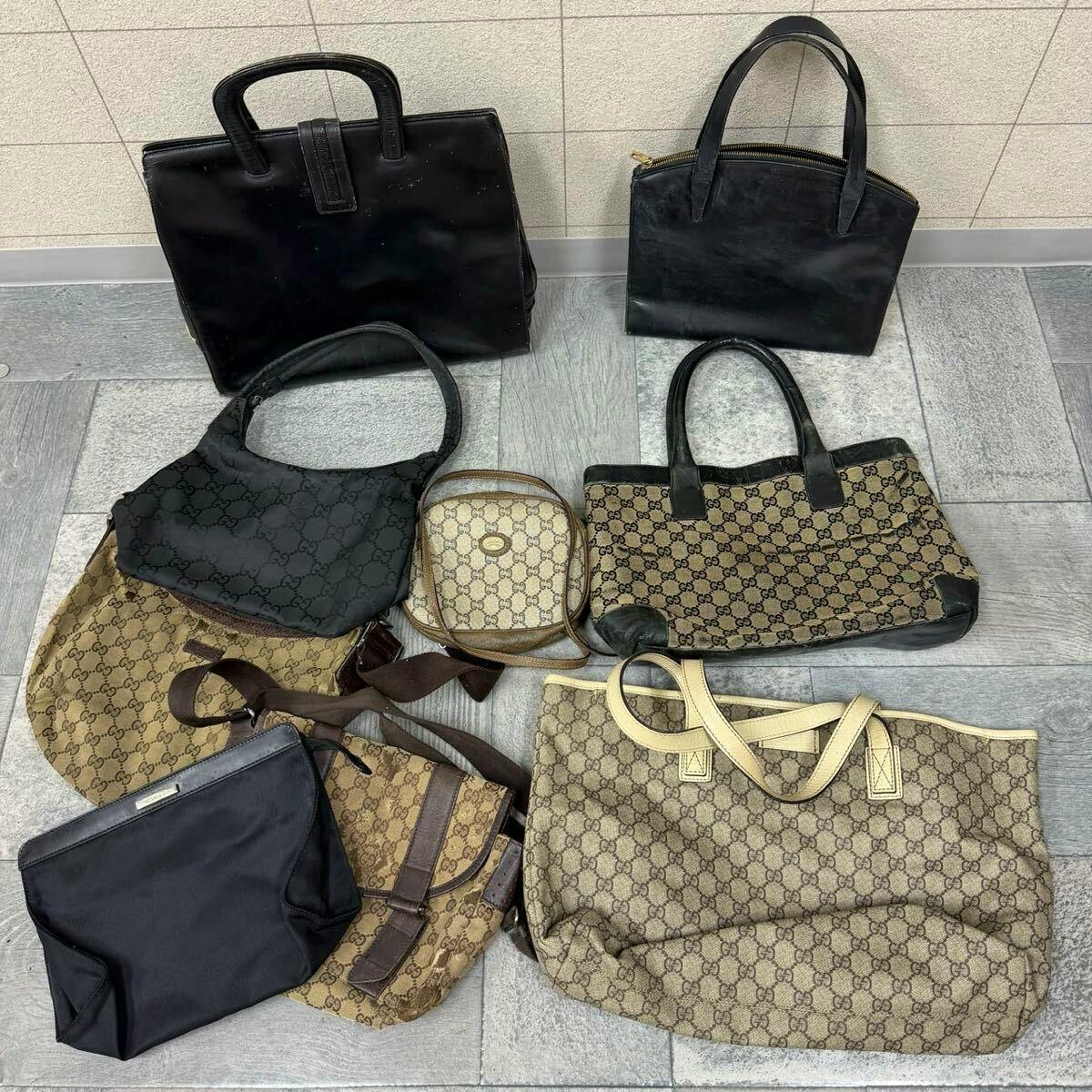 Nine GUCCI bags of various styles arranged on a tiled floor, showing beige GG monogram and black leather bags.