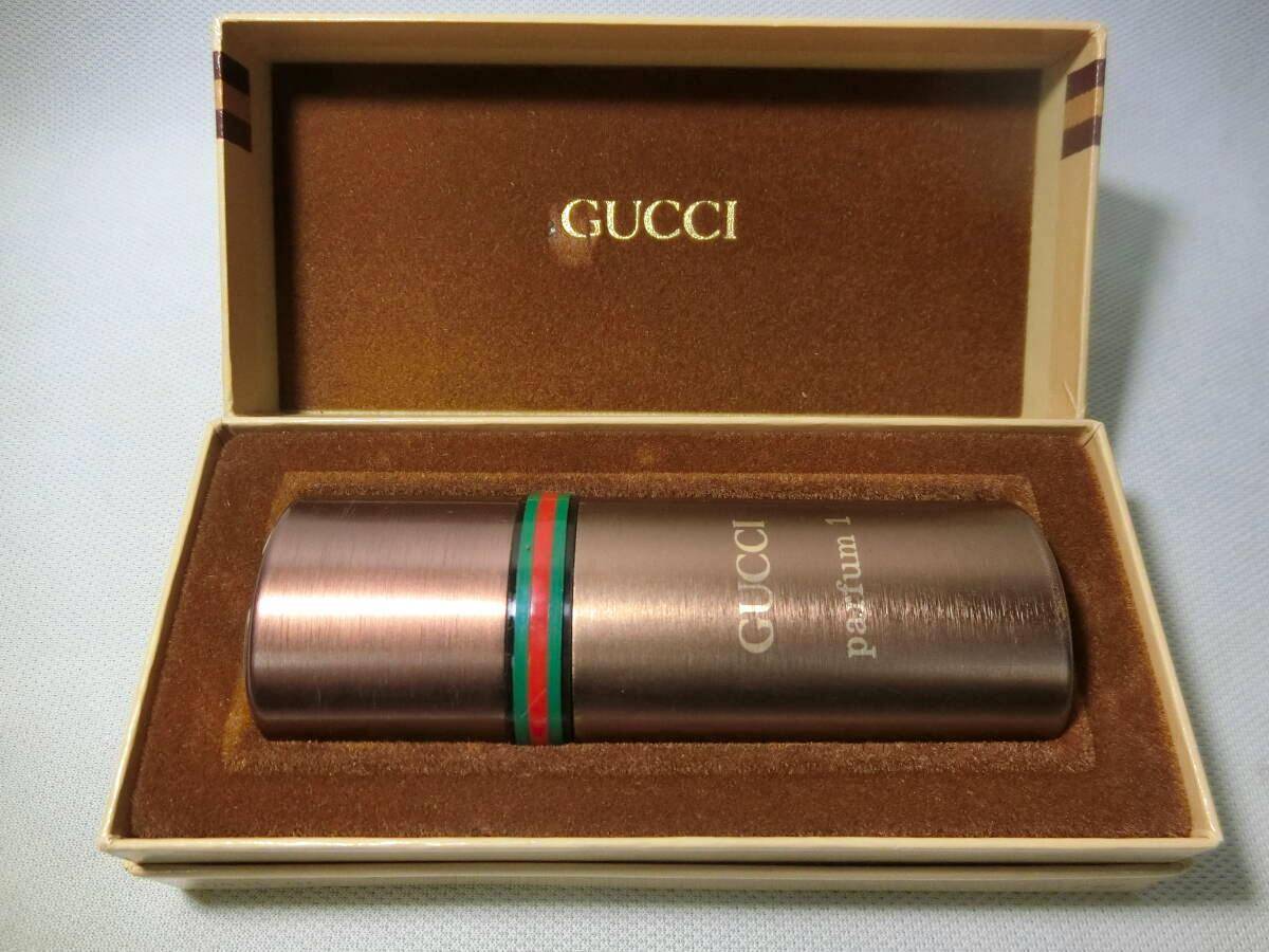 A GUCCI parfum1 metal airspray perfume bottle displayed inside its velvet-lined box with the GUCCI logo on the lid.