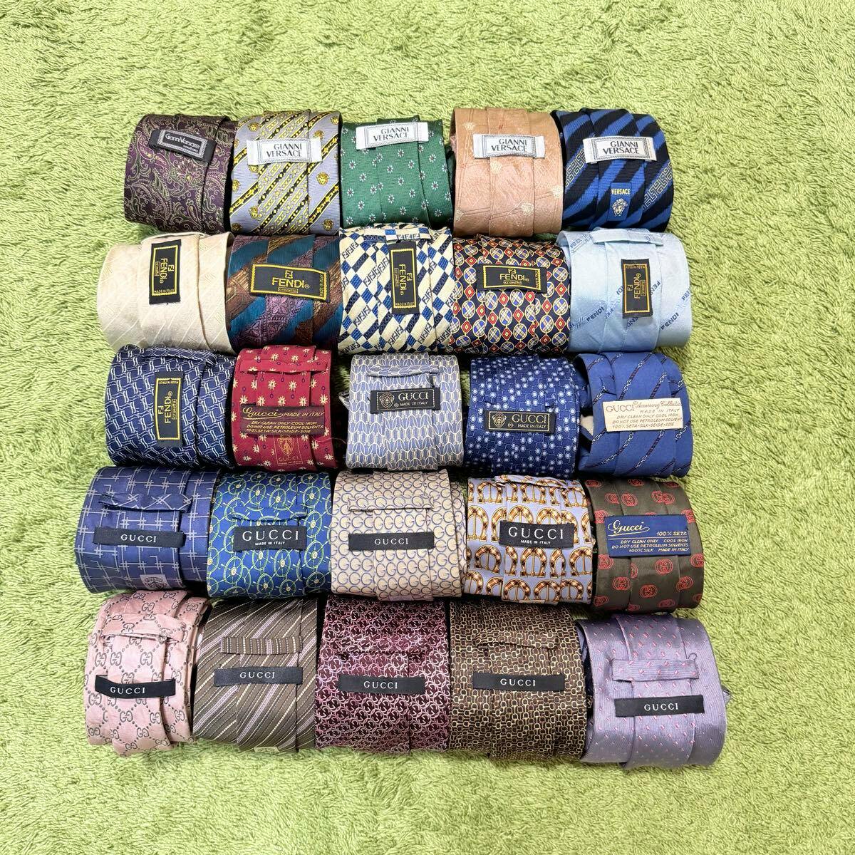 Rolled silk neckties with visible brand labels arranged in rows on a green textured background.