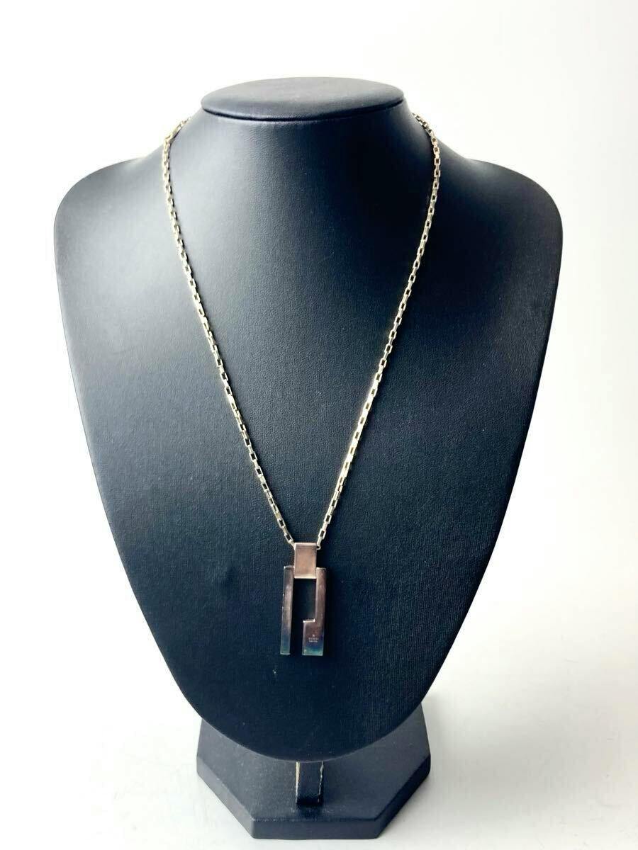 Gucci silver necklace with a G-logo plate pendant displayed on a black bust.