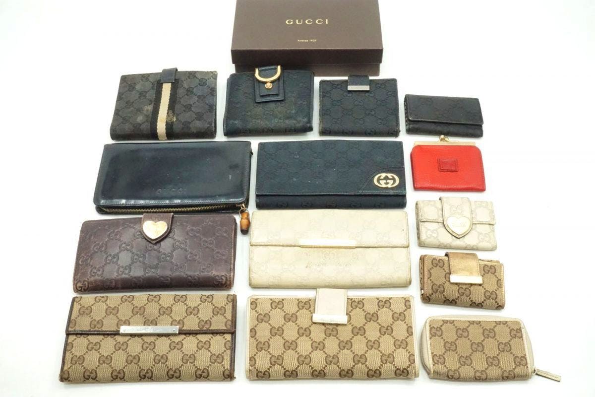 Top-down photo of a set of Gucci wallets and small cases (14-piece set) arranged on a white background with a Gucci box.