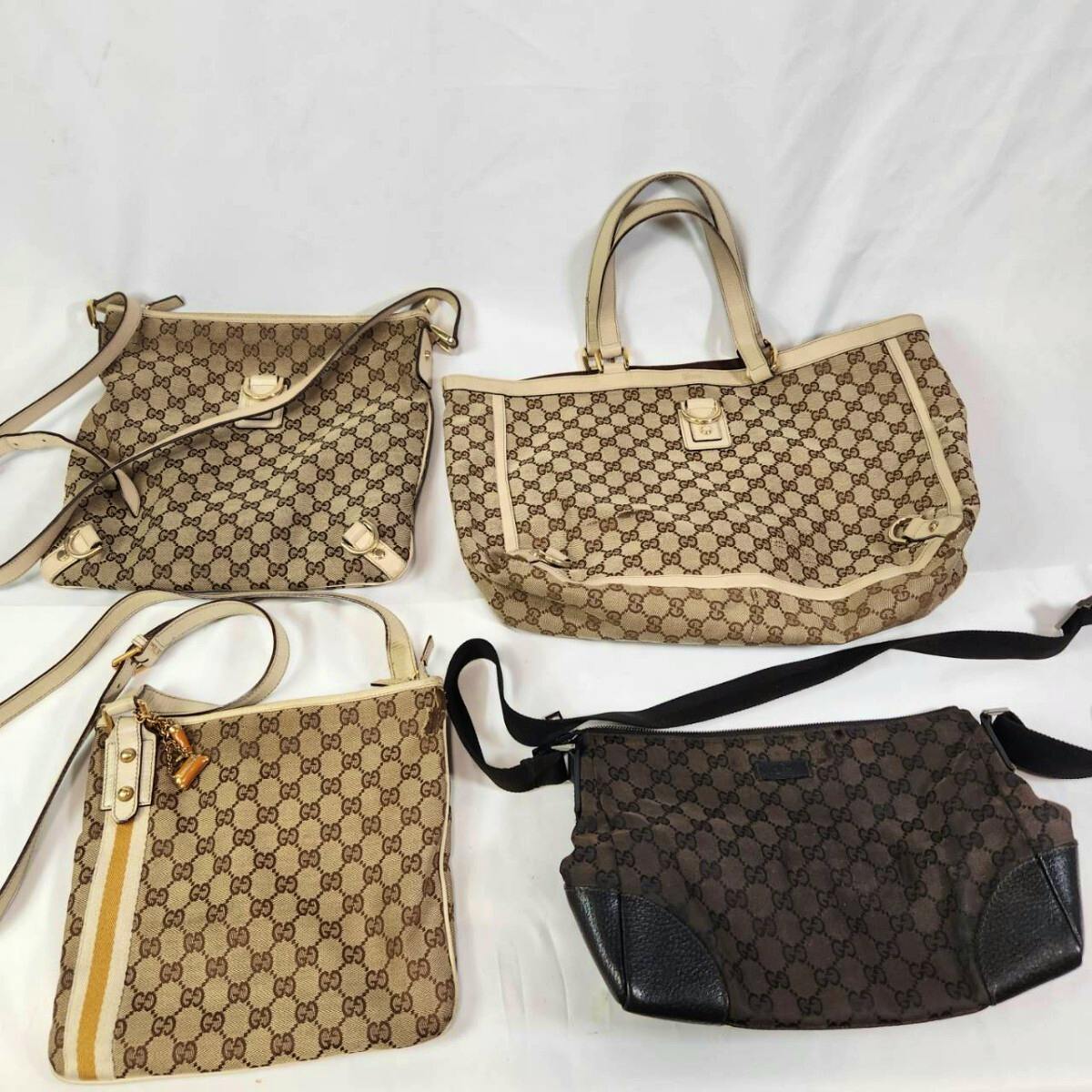 Four GUCCI GG canvas bags (tote and crossbody styles) arranged on a white background.