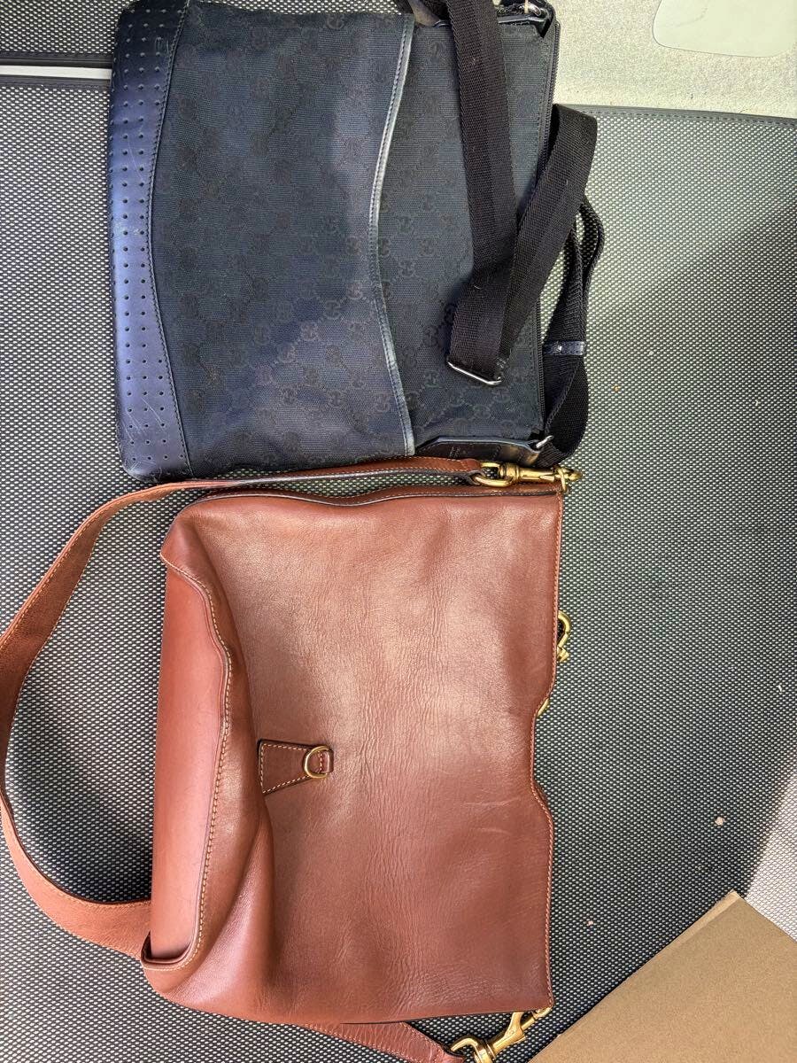 Two GUCCI shoulder bags laid flat: a black GG-pattern crossbody bag at the top and a brown leather shoulder bag below.