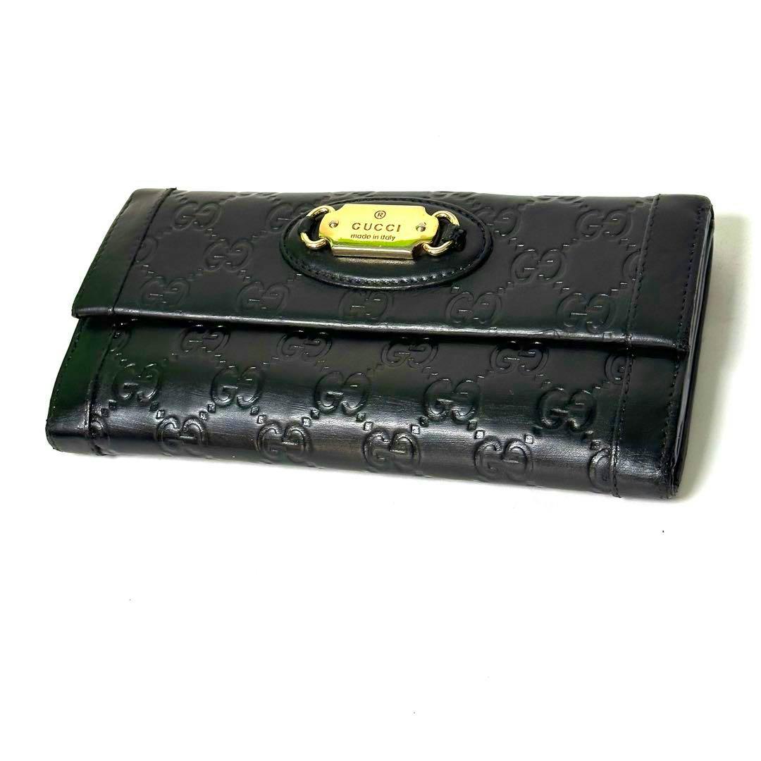 Black GUCCI long leather wallet with embossed GG pattern and a gold metal logo plate on the front.