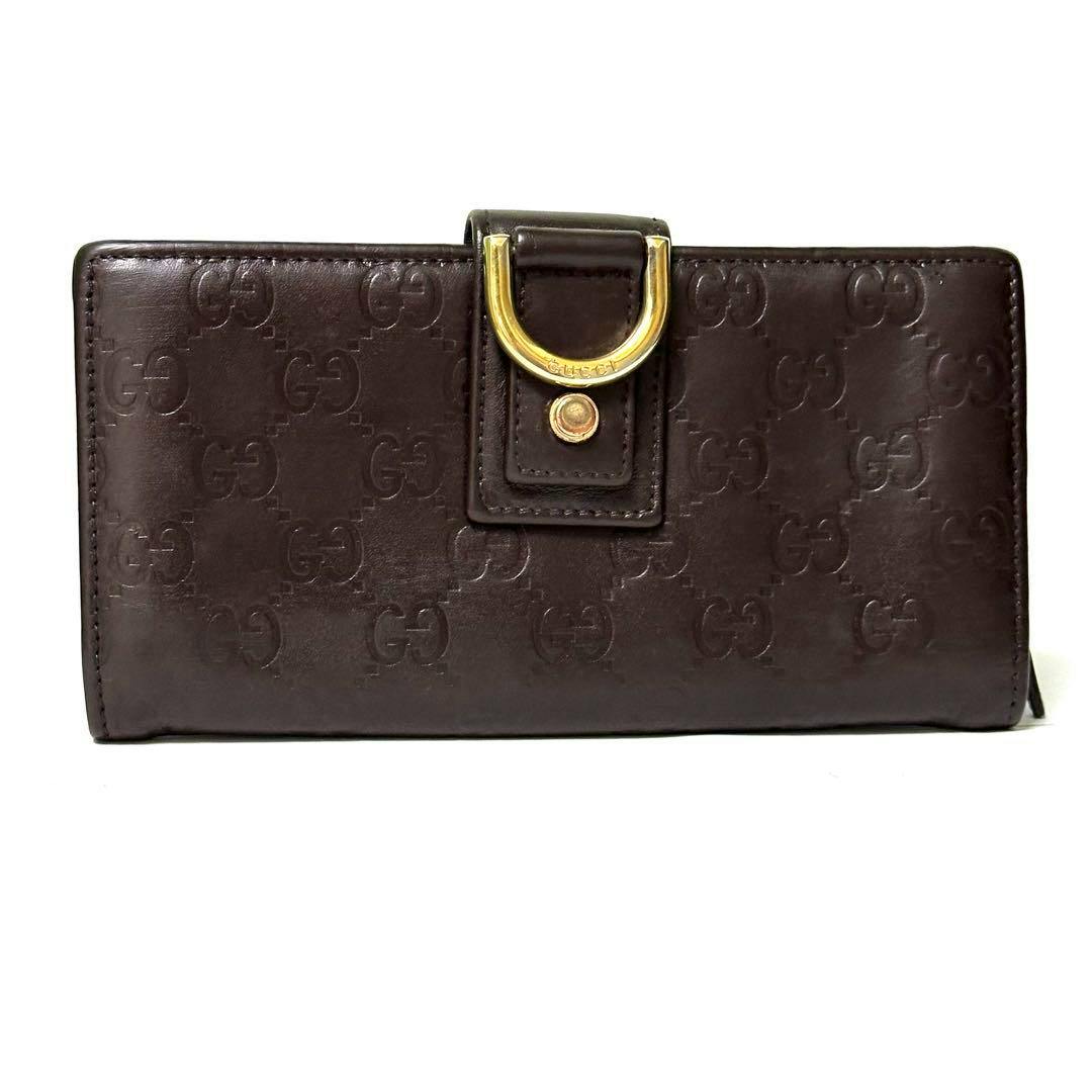 Brown Gucci long leather wallet with embossed GG pattern and a gold-toned horsebit metal logo on the front.