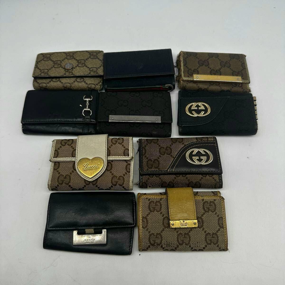 Set of Gucci key cases in various GG canvas and leather designs arranged on a white background.