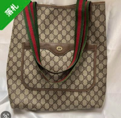 Front view of a Gucci GG-pattern tote bag with green-red striped shoulder straps and an external front pocket.