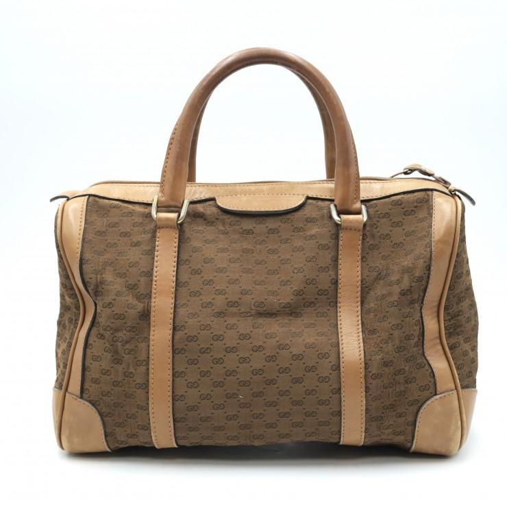 Front view of a brown Gucci mini Boston bag in GG canvas with leather trim and double top handles.