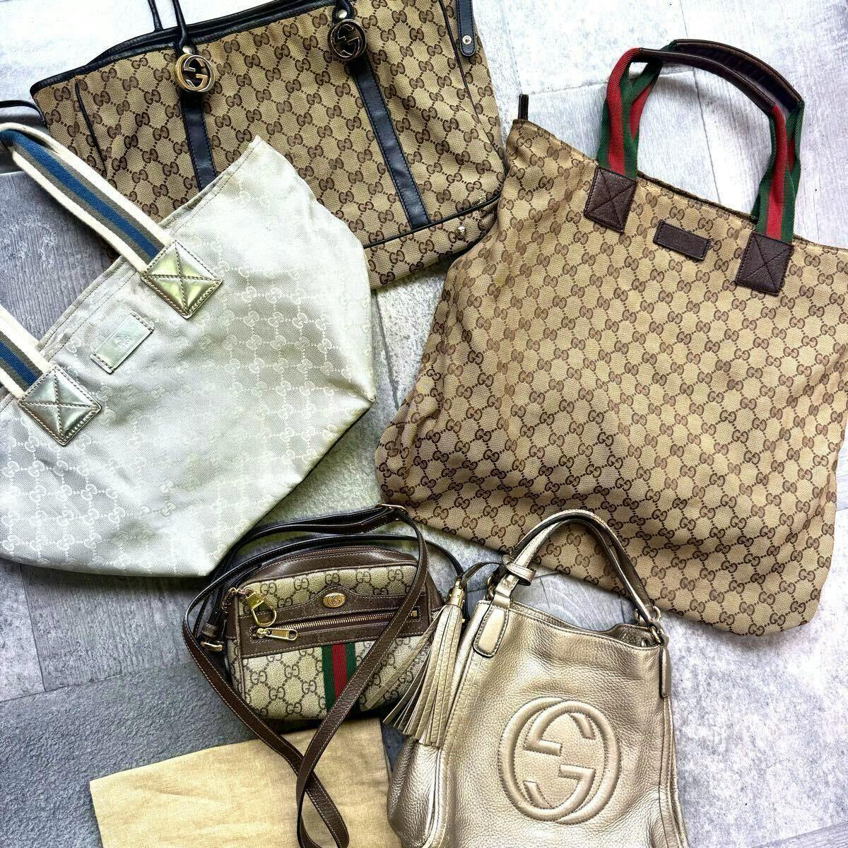 Flat lay of a set of Gucci bags showing several GG canvas totes and smaller shoulder bags from the described set.