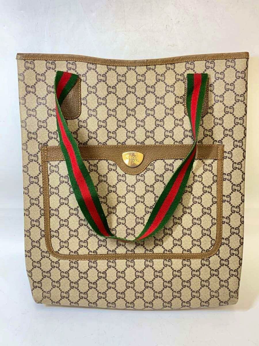 Beige GUCCI PLUS patterned tote bag with green-red-green shoulder straps and a front pocket with a gold emblem.