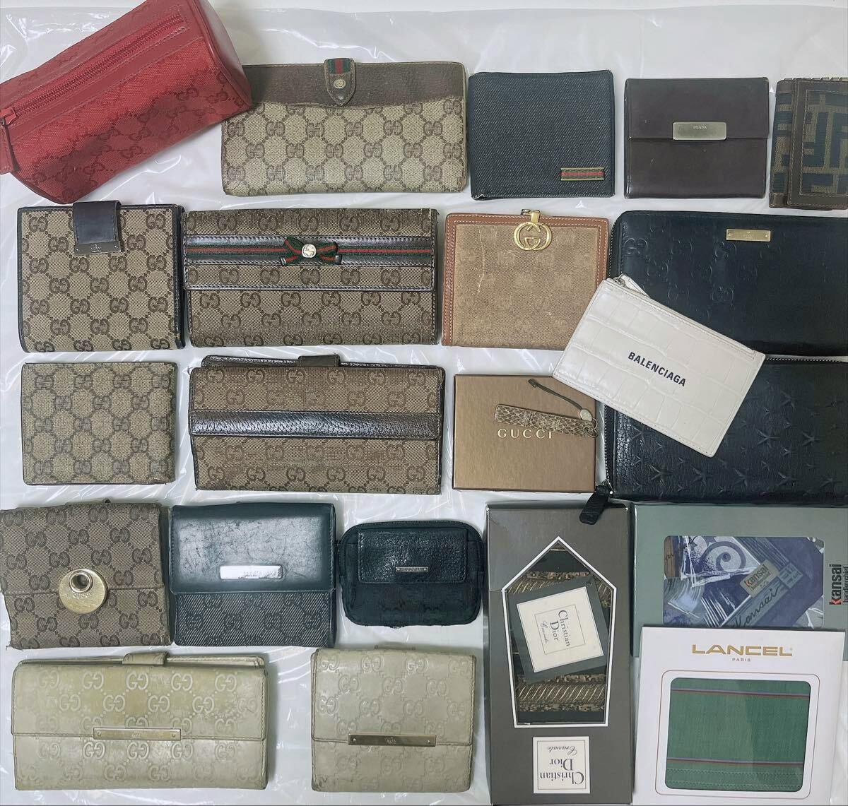 Top-down photo showing an assortment of branded wallets and small cases arranged on a surface, many with Gucci monogram patterns.