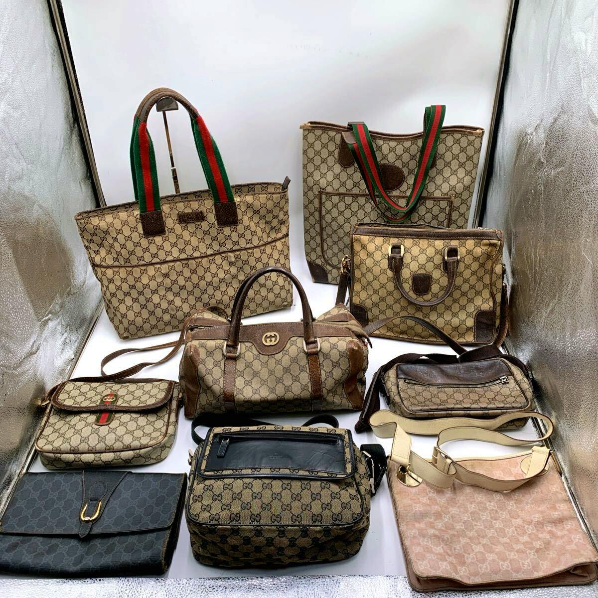 Multiple Gucci GG Supreme canvas bags and totes arranged together on a white background.