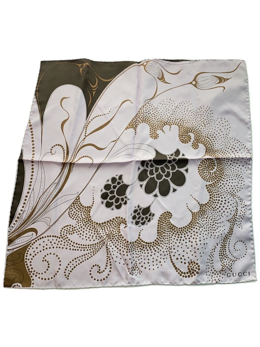 Square silk scarf laid flat showing cream, olive, and gold floral and dotted pattern with "GUCCI" printed in a corner.