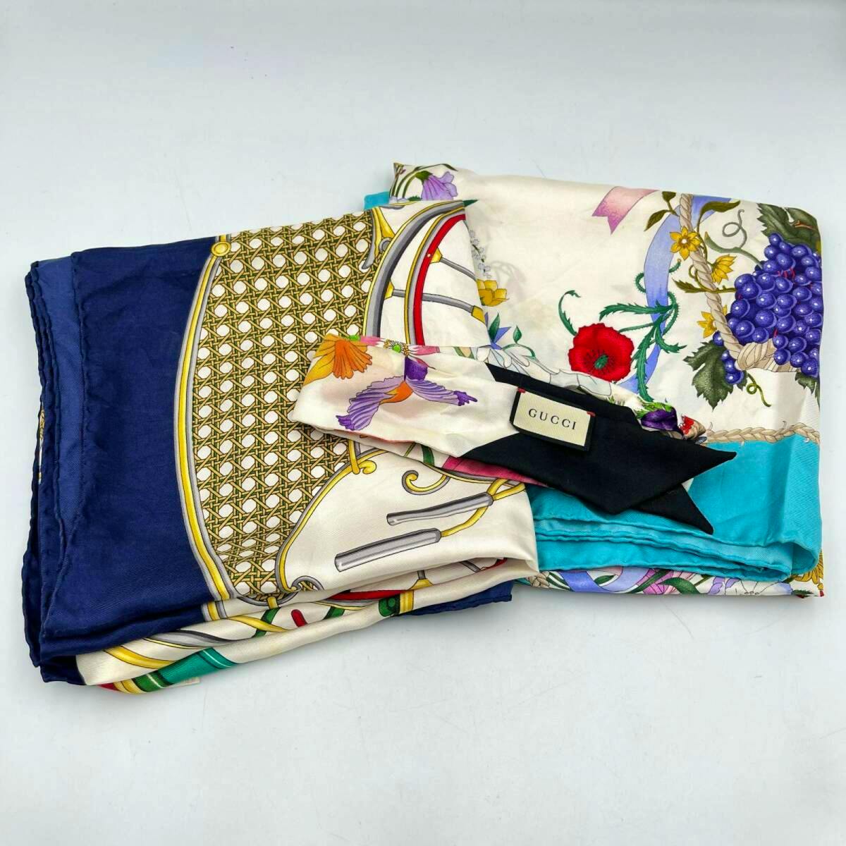 Folded colorful silk Gucci scarves with a visible GUCCI label on a white background.