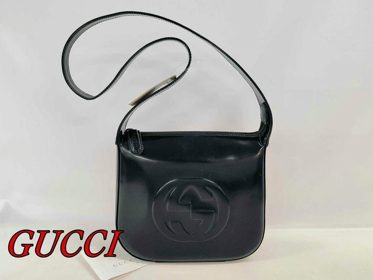 Black GUCCI Soho enamel one-shoulder bag with embossed double-G logo and shoulder strap on a white background.