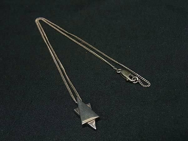 GUCCI silver-tone star pendant necklace laid flat on a black fabric background showing the chain and pendant.