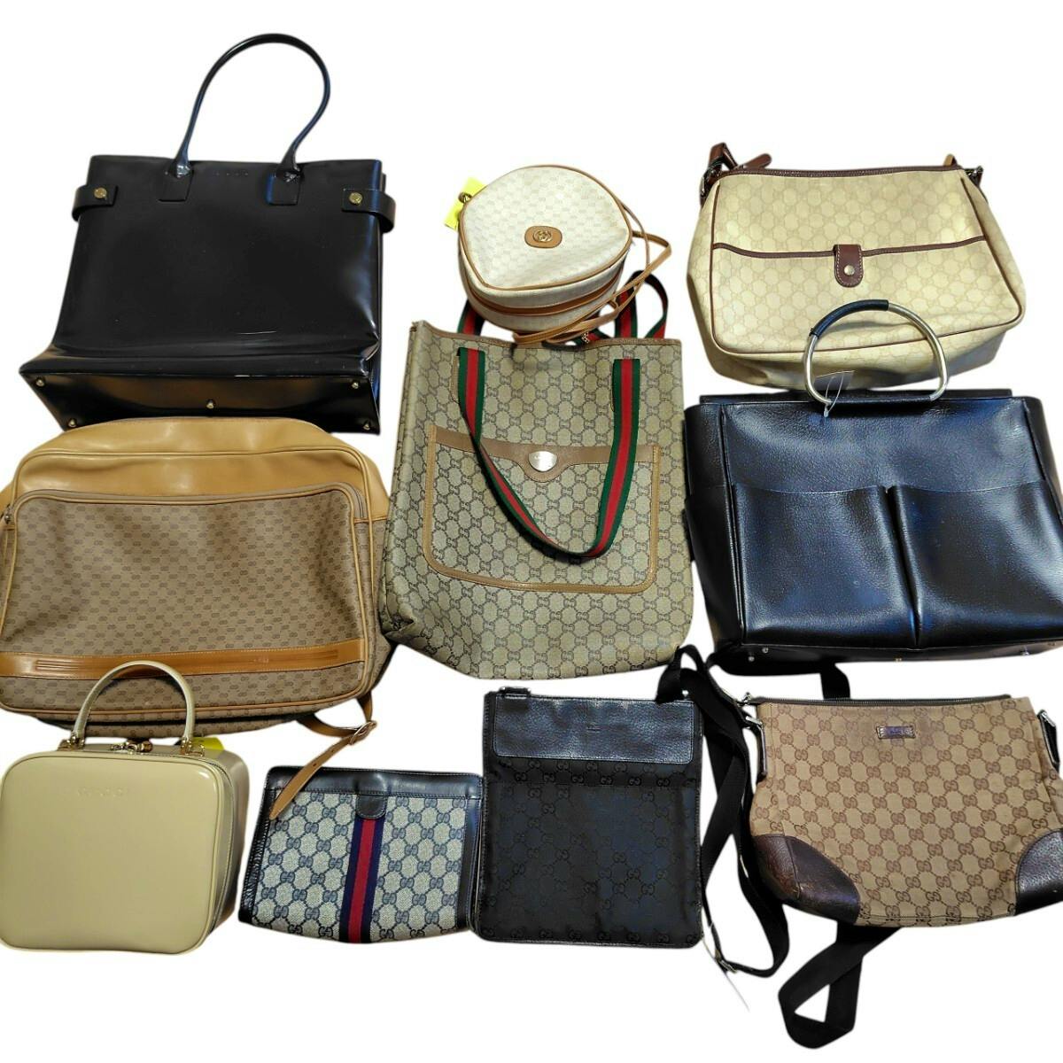 Group of Gucci canvas and leather bags arranged together on a white background.