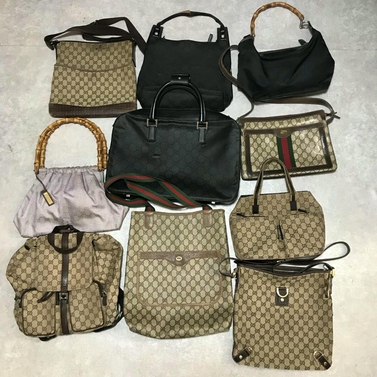 Ten GUCCI bags (GG canvas and black styles) including bamboo-handle and shoulder totes arranged on a floor.