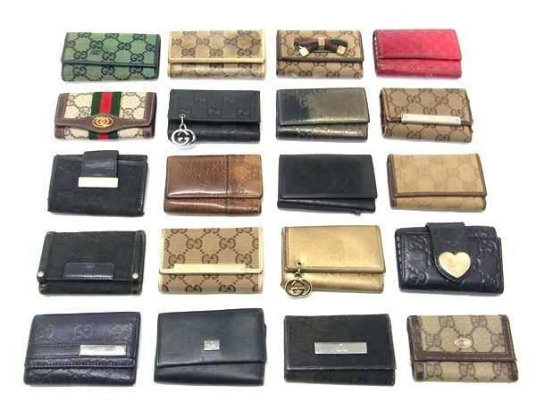 Twenty GUCCI key cases and small wallets arranged in rows on a white background.
