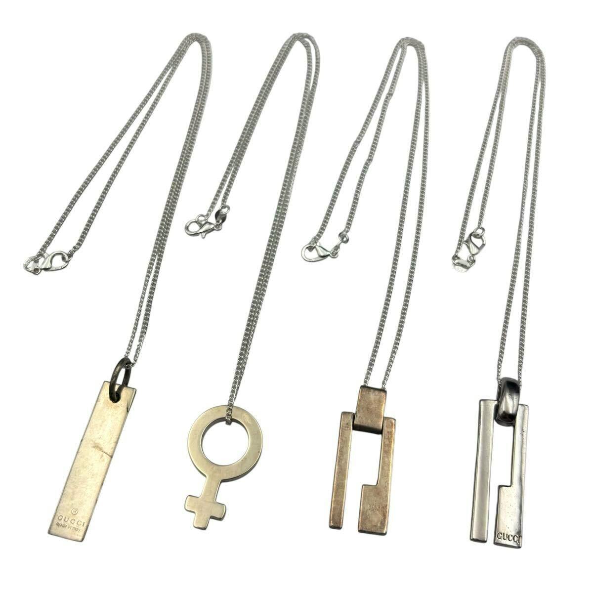 Four GUCCI silver necklaces with different pendant designs arranged side by side on a white background.