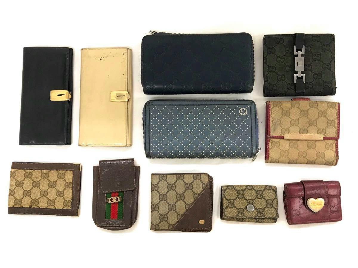 Eleven GUCCI wallets and small cases in GG canvas and leather arranged on a white background.