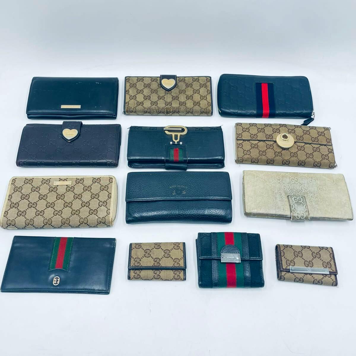A 13-piece set of Gucci wallets and small wallets arranged in rows on a white background.